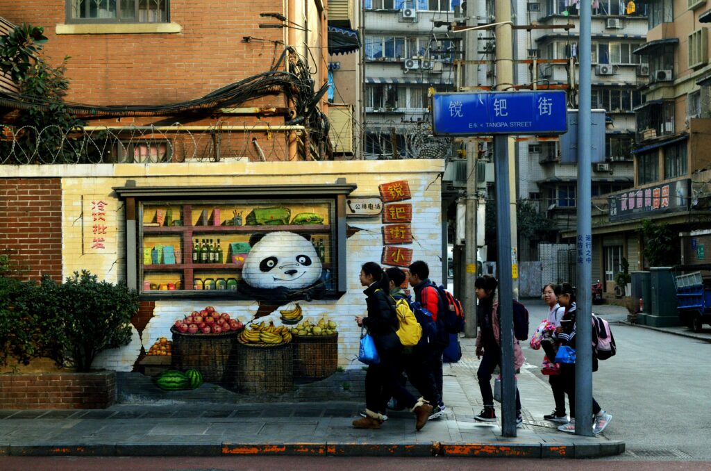Vibrant street corner with urban graffiti art and a group of people walking by.